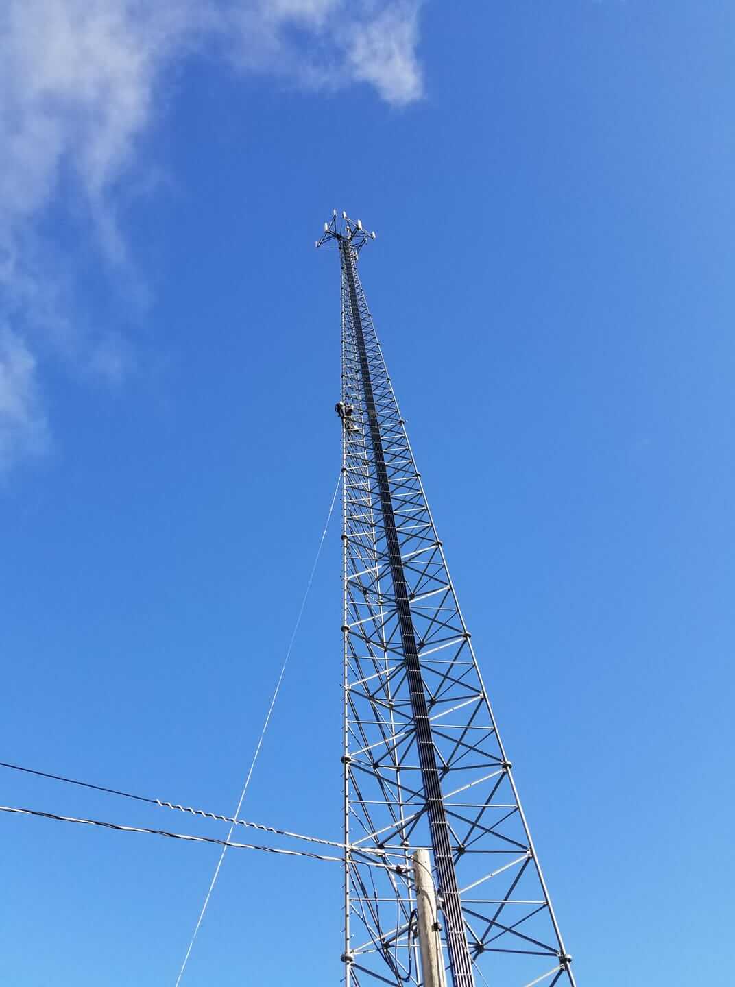 Telecommunication tower on cloud sky background